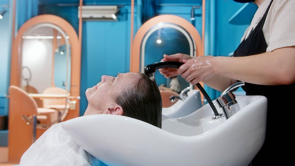 A senior woman gets a relaxing hair wash at a vibrant, modern salon setting