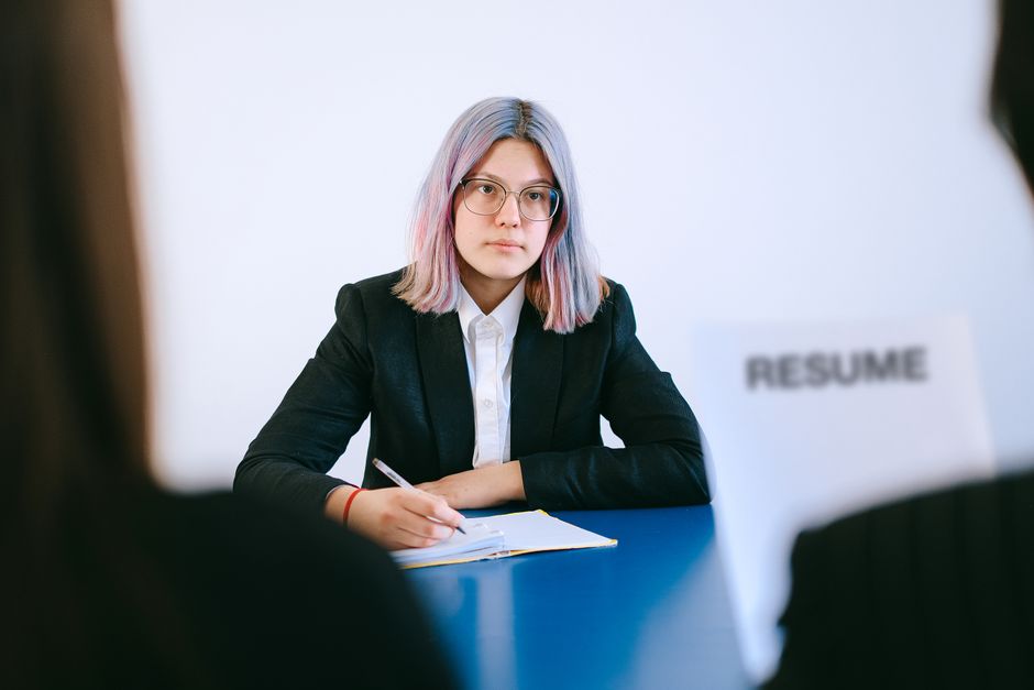 Mujer en entrevista de trabajo tomando notas